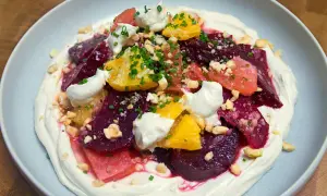 Deliciosa ensalada de remolacha con cítricos, crema y frutos secos picados.