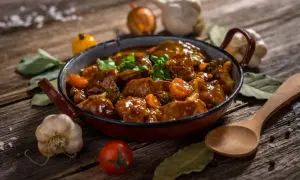 Un delicioso ragout de ternera, con trozos de zanahoria y brócoli, servido en una sartén rústica. Acompañado de ajo, tomate y laurel.