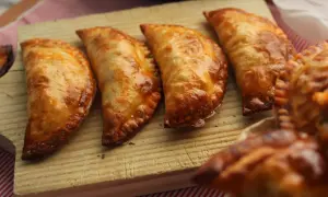 Cuatro empanadillas al horno doradas y crujientes, listas para disfrutar.