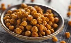 Un tazón lleno de garbanzos fritos dorados y crujientes, perfectos para un aperitivo saludable.