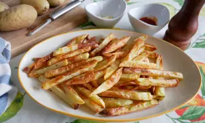 Patatas fritas doradas y crujientes, recién salidas de la freidora de aire. Perfectas para acompañar cualquier comida.