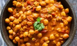 Un cremoso curry de garbanzos con tomate y especias, adornado con cilantro fresco. Un plato reconfortante y lleno de sabor.