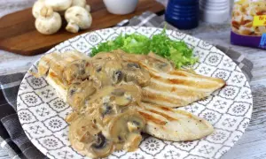 Sabroso pollo con champiñones en salsa cremosa, servido con lechuga fresca en un plato decorado.