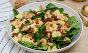 Deliciosa ensalada de espinacas con trozos de manzana, pasas y nueces crujientes. Un festín de texturas y sabores.