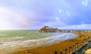 Vista panorámica de la playa del Russo en Peñíscola, con el castillo al fondo y el mar Mediterráneo.