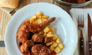 Sabroso conejo guisado en salsa con patatas fritas crujientes. Un plato casero que invita a disfrutar.