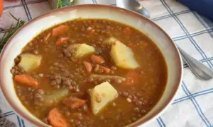 Un tazón humeante de lentejas estofadas Arguiñano, con patatas y zanahorias, listo para disfrutar.