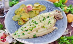 Delicioso lenguado al horno con patatas panadera y perejil fresco. Un plato ligero y sabroso.