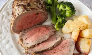 Jugoso roast beef cortado en rodajas, acompañado de brócoli al vapor y patatas asadas crujientes. Un festín para los sentidos.