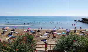 Playa llena de gente disfrutando del sol y el mar. ¡Un día perfecto para saber qué hacer en Alcossebre!