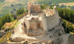 El imponente castillo de Xivert se alza sobre una colina, rodeado de vegetación y campos cultivados. Sus ruinas cuentan historias de batallas y épocas pasadas.