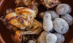 Delicioso conejo al ajillo servido con papas arrugadas cubiertas de sal.
