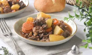 Un reconfortante plato de carne guisada con patatas y zanahorias, servido en un cuenco.