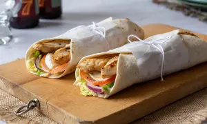 Dos deliciosos wraps de pollo, rellenos de verduras frescas y queso, listos para disfrutar.