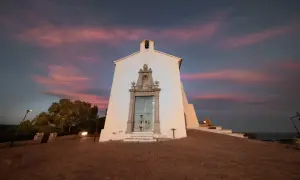 La ermita de Santa Lucía en Alcossebre se alza bajo un cielo crepuscular teñido de rosa y púrpura.