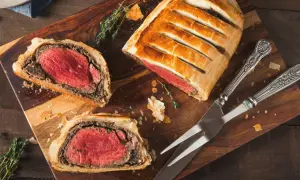 Un delicioso solomillo Wellington, jugoso y envuelto en hojaldre dorado, listo para ser cortado.