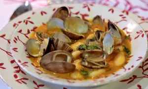 Plato de fabes con almejas, un guiso tradicional con judías blancas tiernas y almejas frescas en una salsa sabrosa.