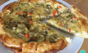 Un delicioso quiche de verduras, con una masa dorada y un relleno cremoso de champiñones, calabacín y zanahoria.