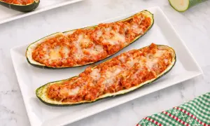 Dos calabacines rellenos de carne y queso gratinado, listos para disfrutar.