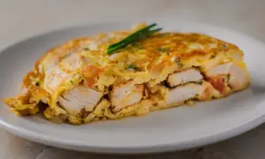 Tortilla de bacalao, jugosa y dorada, con trozos de pescado blanco tierno envueltos en huevo.