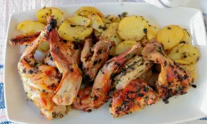 Delicioso conejo al horno con patatas doradas y hierbas aromáticas, listo para servir.