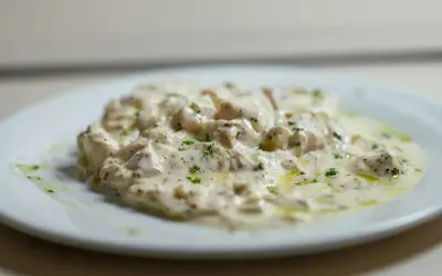 Deliciosa brandada de bacalao cremosa, espolvoreada con perejil fresco y un toque de aceite de oliva.