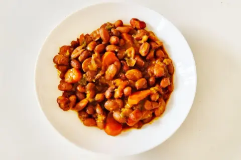 Un plato de judías pintas guisadas con zanahoria y pimientos, un plato casero lleno de sabor.