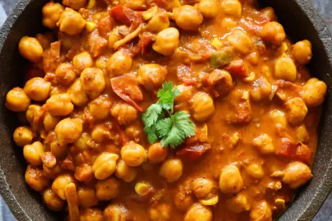 Un cremoso curry de garbanzos con tomate y especias, adornado con cilantro fresco. Un plato reconfortante y lleno de sabor.