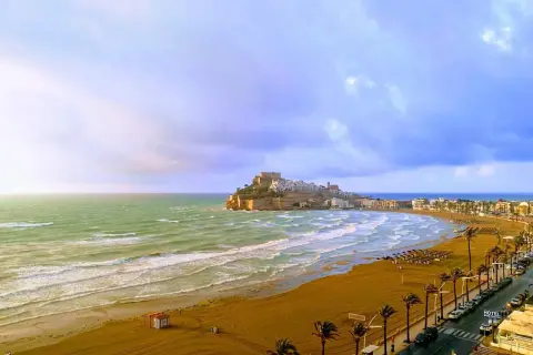 Vista panorámica de la playa del Russo en Peñíscola, con el castillo al fondo y el mar Mediterráneo.