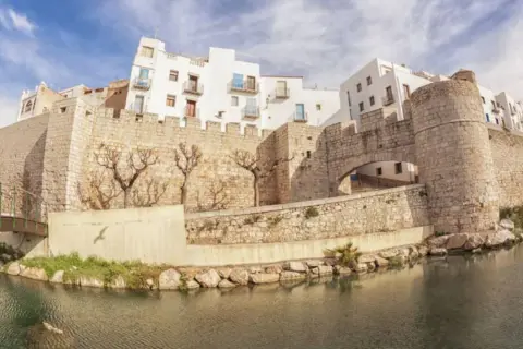 Vista de Peñíscola desde el agua, con su imponente castillo y casas blancas.