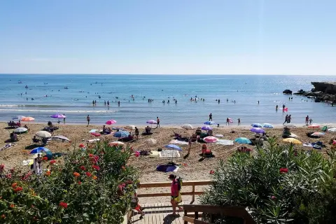 Playa llena de gente disfrutando del sol y el mar. ¡Un día perfecto para saber qué hacer en Alcossebre!