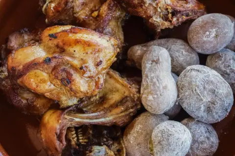 Delicioso conejo al ajillo servido con papas arrugadas cubiertas de sal.