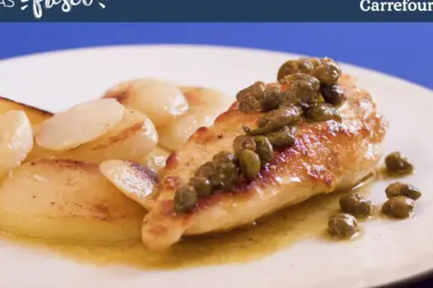 Pechuga de pollo dorada con alcaparras, servida con patatas salteadas en una salsa dorada.