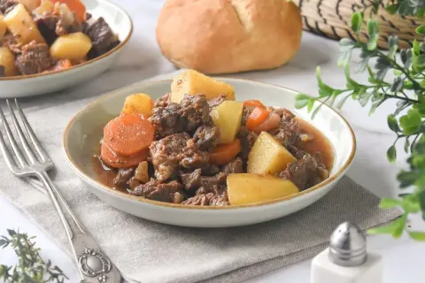 Un reconfortante plato de carne guisada con patatas y zanahorias, servido en un cuenco.