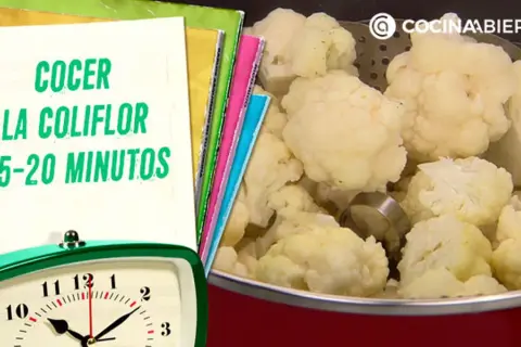 Coliflor cocida en una olla, con un reloj y un cuaderno que indica el tiempo de cocción de la coliflor: 15-20 minutos.