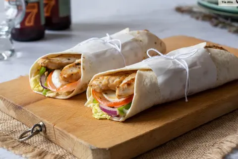 Dos deliciosos wraps de pollo, rellenos de verduras frescas y queso, listos para disfrutar.