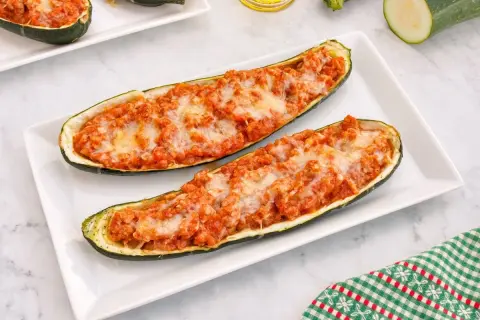 Dos calabacines rellenos de carne y queso gratinado, listos para disfrutar.