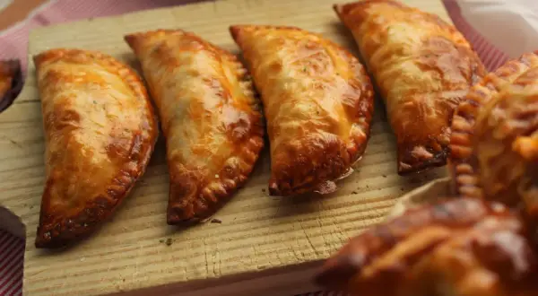 Cuatro empanadillas al horno doradas y crujientes, listas para disfrutar.