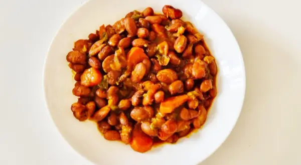 Un plato de judías pintas guisadas con zanahoria y pimientos, un plato casero lleno de sabor.