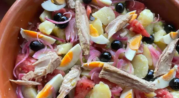 Deliciosa ensalada campera con patatas, huevo duro, atún, aceitunas negras y cebolla morada. ¡Un plato fresco y completo!