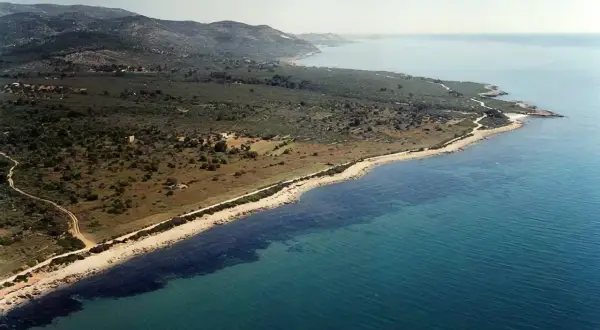 Costa salvaje con vegetación y mar turquesa. La cala Petxina en Peñíscola, un rincón idílico para explorar.