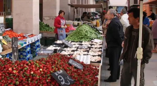 Gente comprando fresas, tomates y judías en el mercadillo semanal Benicarló.