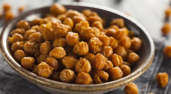 Un tazón lleno de garbanzos fritos dorados y crujientes, perfectos para un aperitivo saludable.