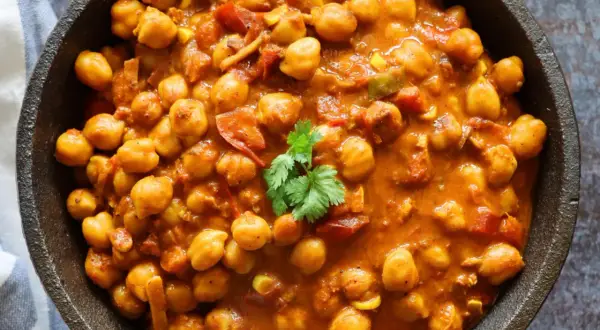 Un cremoso curry de garbanzos con tomate y especias, adornado con cilantro fresco. Un plato reconfortante y lleno de sabor.