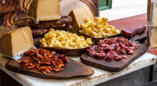 Tabla con quesos y embutidos, incluyendo un delicioso tartar de salchichón, listo para degustar.