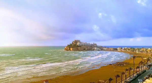 Vista panorámica de la playa del Russo en Peñíscola, con el castillo al fondo y el mar Mediterráneo.