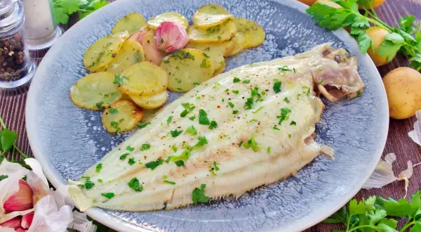 Delicioso lenguado al horno con patatas panadera y perejil fresco. Un plato ligero y sabroso.