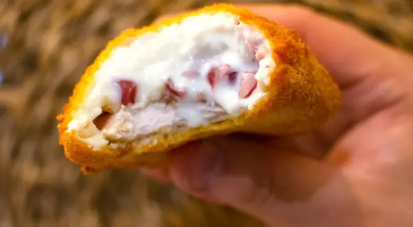 Pechuga villaroy crujiente por fuera, jugosa por dentro, con trocitos de jamón y bechamel cremosa.