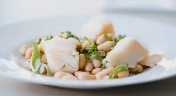 Deliciosa ensalada de bacalao con tiernas judías blancas y hierbas frescas. Un plato ligero y sabroso.