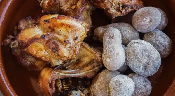 Delicioso conejo al ajillo servido con papas arrugadas cubiertas de sal.